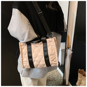 Detailed side view of quilted nylon crossbody bag with detachable wide black strap