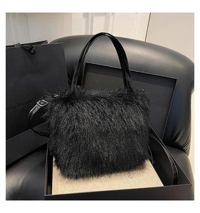 Detail van zwarte faux fur handtas met lederen handgrepen in luxe geschenkverpakking