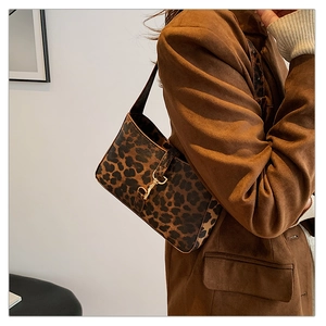 Détail du sac hobo à imprimé léopard avec boucle en métal doré et texture en daim