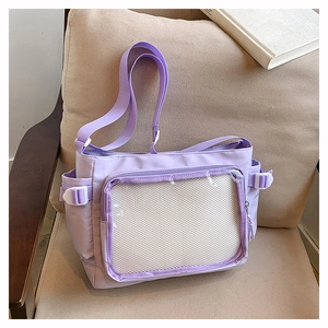 Detail view of the purple ita bag featuring a large clear front pocket and canvas texture