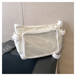 Close-up of white canvas tote with mesh pocket and side buckle straps for ITA bag customization