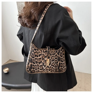 Detail view of leopard print shoulder bag with gold metal buckle and structured texture