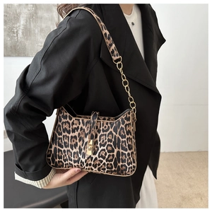 Detailed view of leopard print shoulder bag with gold chain strap and twist lock