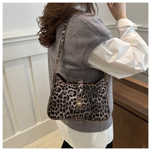 Close-up of leopard print shoulder bag featuring a sleek golden metal twist lock buckle