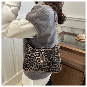 Close-up of leopard print shoulder bag featuring gold chain strap and metal lock detail