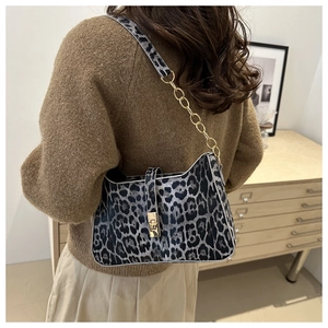 Detail of leopard print shoulder bag with gold chain strap and metallic lock closure