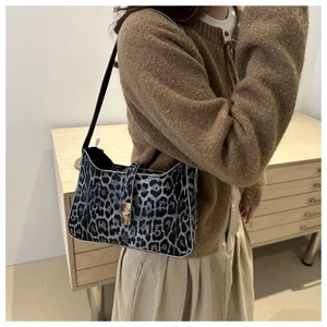 Detailed close-up of a leopard print underarm bag featuring a stylish metallic buckle