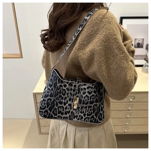 Detailed side view of trendy leopard print underarm bag with metallic buckle closure