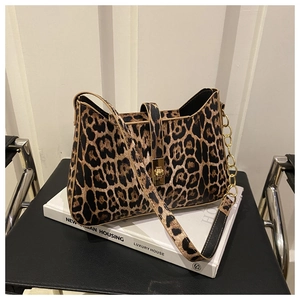 Detail of leopard print leather handbag with golden twist lock on urban books