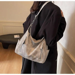 Detail view of large gray matte hobo bag worn by model showing its texture and capacity