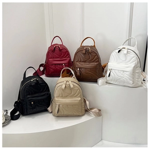 Detailed close-up of colorful mini quilted PU leather backpacks on a white display