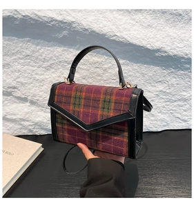 Détail du tissu à carreaux vintage et de la garniture en cuir sur un sac bandoulière