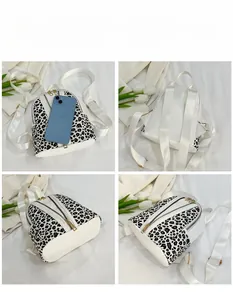 Detail view of mini leopard print backpack showing size comparison with a smartphone
