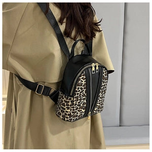 Detailed back view of a compact leopard print backpack featuring dual gold zippers