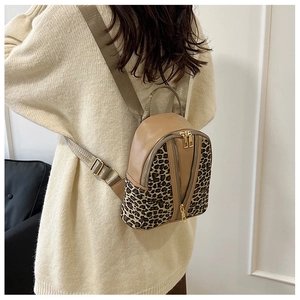 Detail of mini leopard print backpack with dual golden zippers and khaki fabric straps
