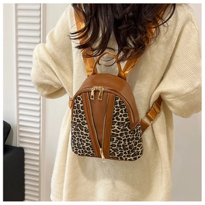 Close-up of leopard print mini backpack with golden double zippers and brown straps