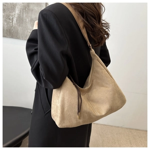 Dettaglio della borsa hobo in pelle scamosciata con nappe marroni e cuciture a contrasto