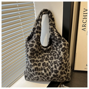 Gros plan d'un sac cabas pelucheux à motif léopard en tissu doux avec anse assortie