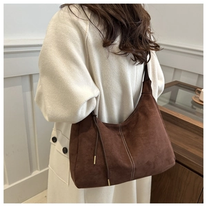 Borsa sottobraccio in pelle scamosciata marrone con cuciture a contrasto e nappe sul modello