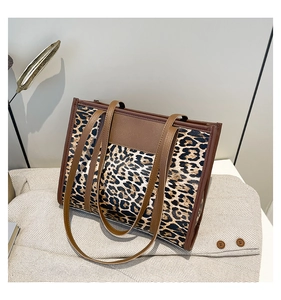 Close-up of leopard print tote bag with brown leather handles and spacious interior