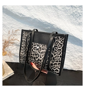 Detail of leopard print tote bag featuring matte black straps and high-quality texture
