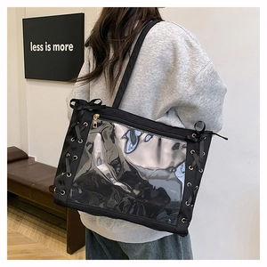 Dettaglio della borsa tote nera con finestra in PVC e fiocchi decorativi neri
