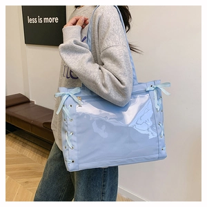 Detail of light blue ita bag showing large clear PVC window and silk ribbon bow knots