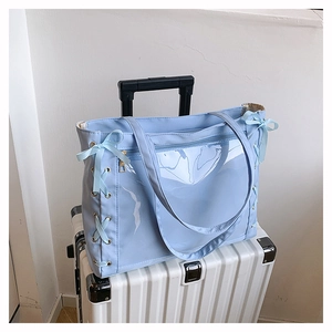 Dettaglio della borsa tote azzurra con finestra trasparente e fiocchi decorativi