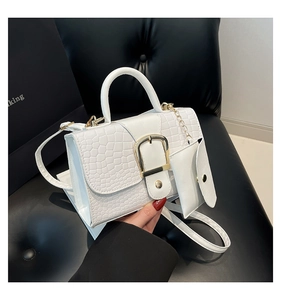Détail du sac à main blanc motif crocodile avec boucle dorée et mini pochette
