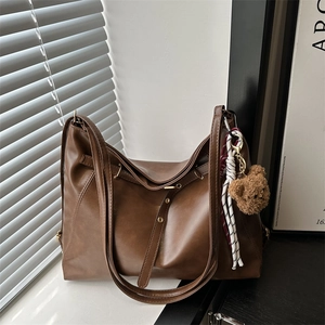 Retro dark brown PU leather tote bag with plush bear charm and woven tassel detail