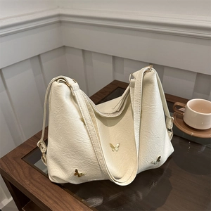 Creamy beige pleated butterfly shoulder bag with gold metal charms and premium PU texture