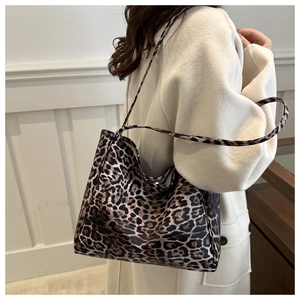 Chic leopard print tote bag with double straps worn on shoulder by a model in beige coat