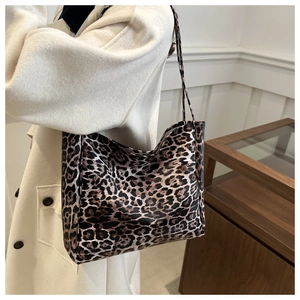 Detailed close-up of leopard print tote bag being carried by a model in a minimal setting
