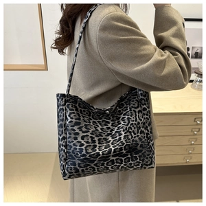 Detail of a large leopard print tote bag styled with a beige coat for a casual autumn look