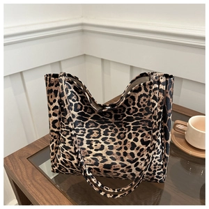 Detail of leopard print tote bag with brown faux leather texture and metallic snap button