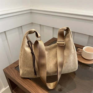 Borsa a spalla retrò in camoscio color cammello con tracolla su tavolo di legno