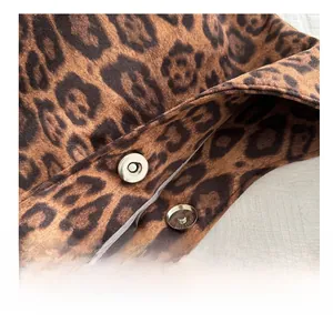 Detail showing the silver magnetic buckle on a fuzzy leopard print tote bag texture