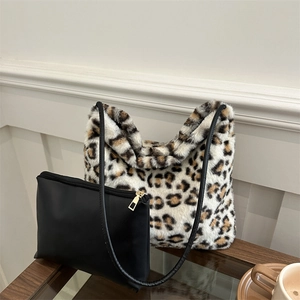 Borsa tote in ecopelliccia leopardata con pochette nera coordinata su tavolo in vetro
