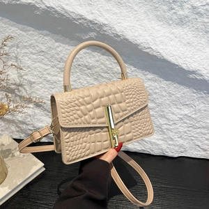 Beige crocodile embossed square handbag with golden bar lock and top handle strap