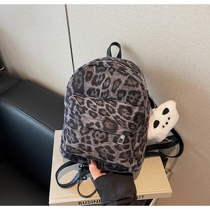 Close-up of grey leopard print mini backpack with plush texture and ghost keychain