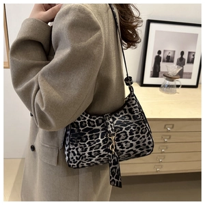 Vue détaillée du sac baguette léopard avec boucle métallique et bandoulière réglable