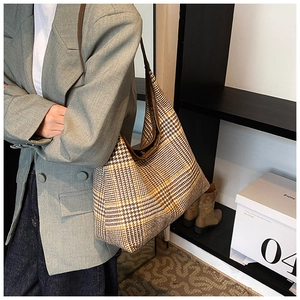 Close-up of a large houndstooth shoulder bag for women with elegant brown shoulder straps
