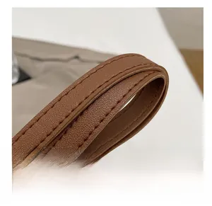 Close-up of durable brown leather shoulder strap with reinforced double stitching details