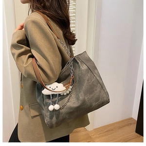 Side view of large grey canvas tote bag with chain strap and cloud charm detail