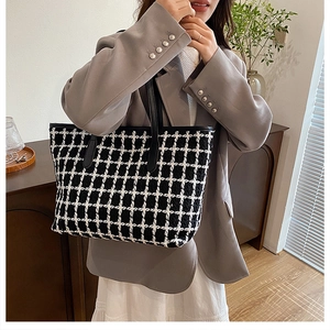 Close-up of black and white plaid tweed tote bag with premium leather handles