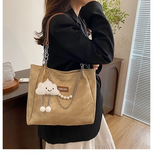 Détail du sac cabas en daim kaki avec chaînes argentées et pendentif nuage blanc