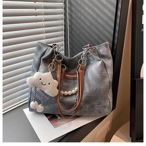 Détail d'un sac cabas gris vintage avec chaîne en perles et pendentif nuage