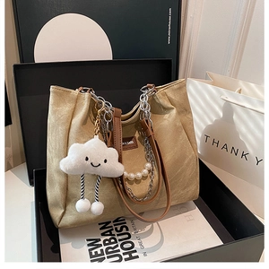 Détail du sac cabas kaki avec bandoulière en perles et pendentif nuage en peluche