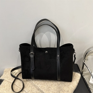 Black matte tote bag with silver studs and a detachable strap for daily commute