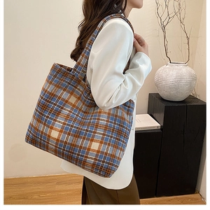 Detail of classic plaid tote bag in blue and orange wool with wide shoulder strap